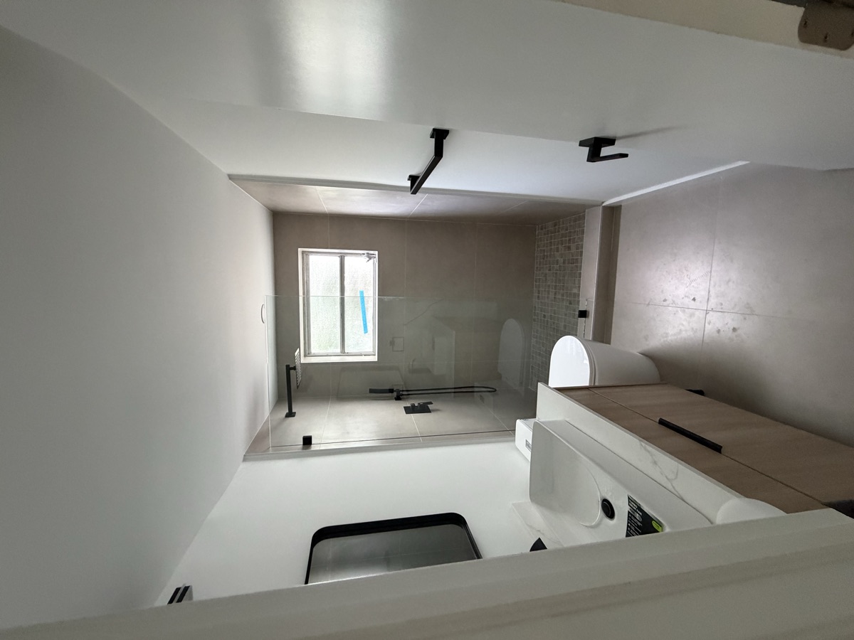 Remodeled bathroom with wood vanity and walk-in shower with window