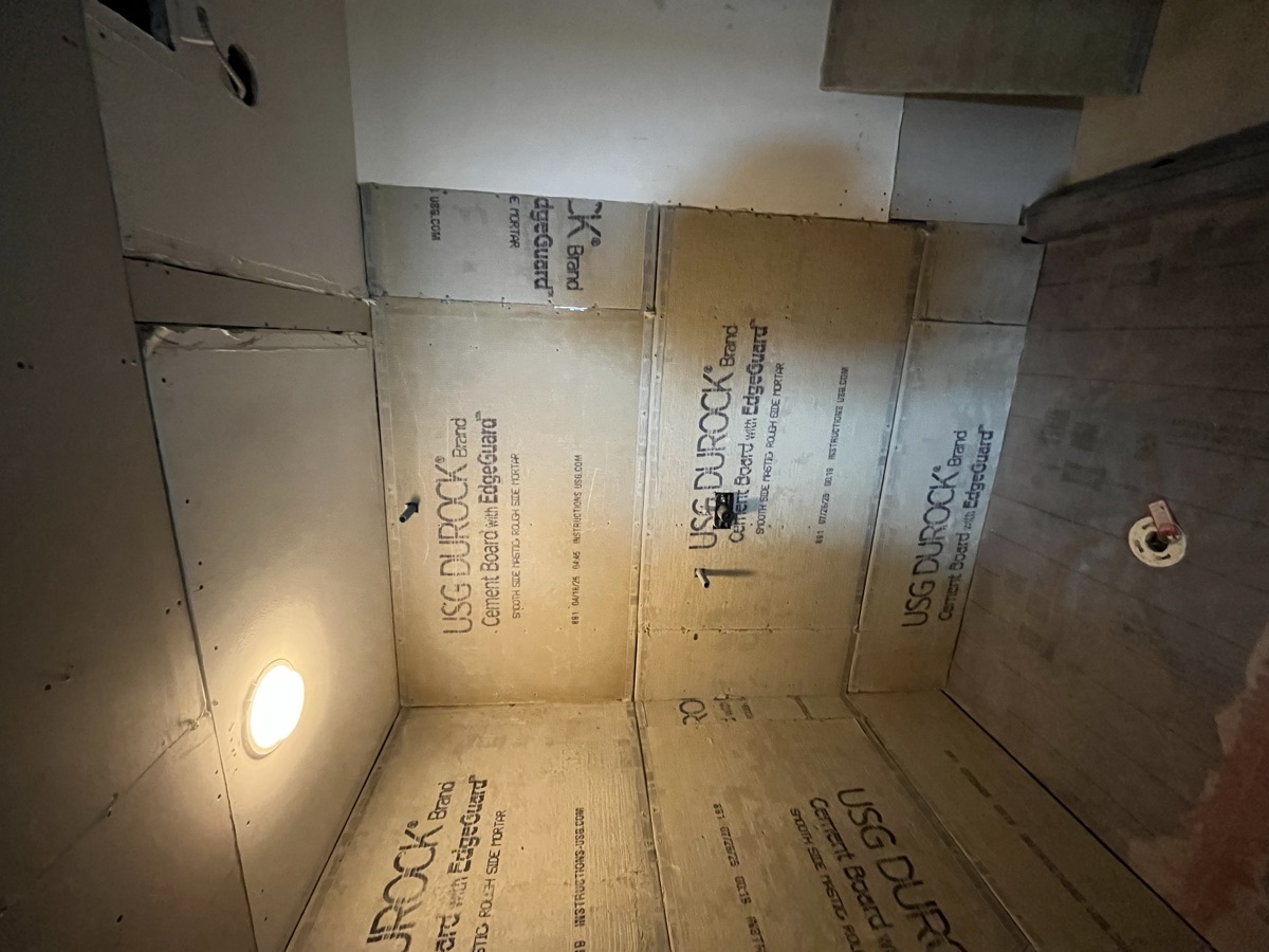 Shower in cement board with ceiling light, ready for tile