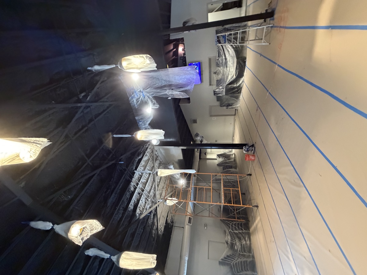 Commercial hall with ceiling painted black, floors protected
